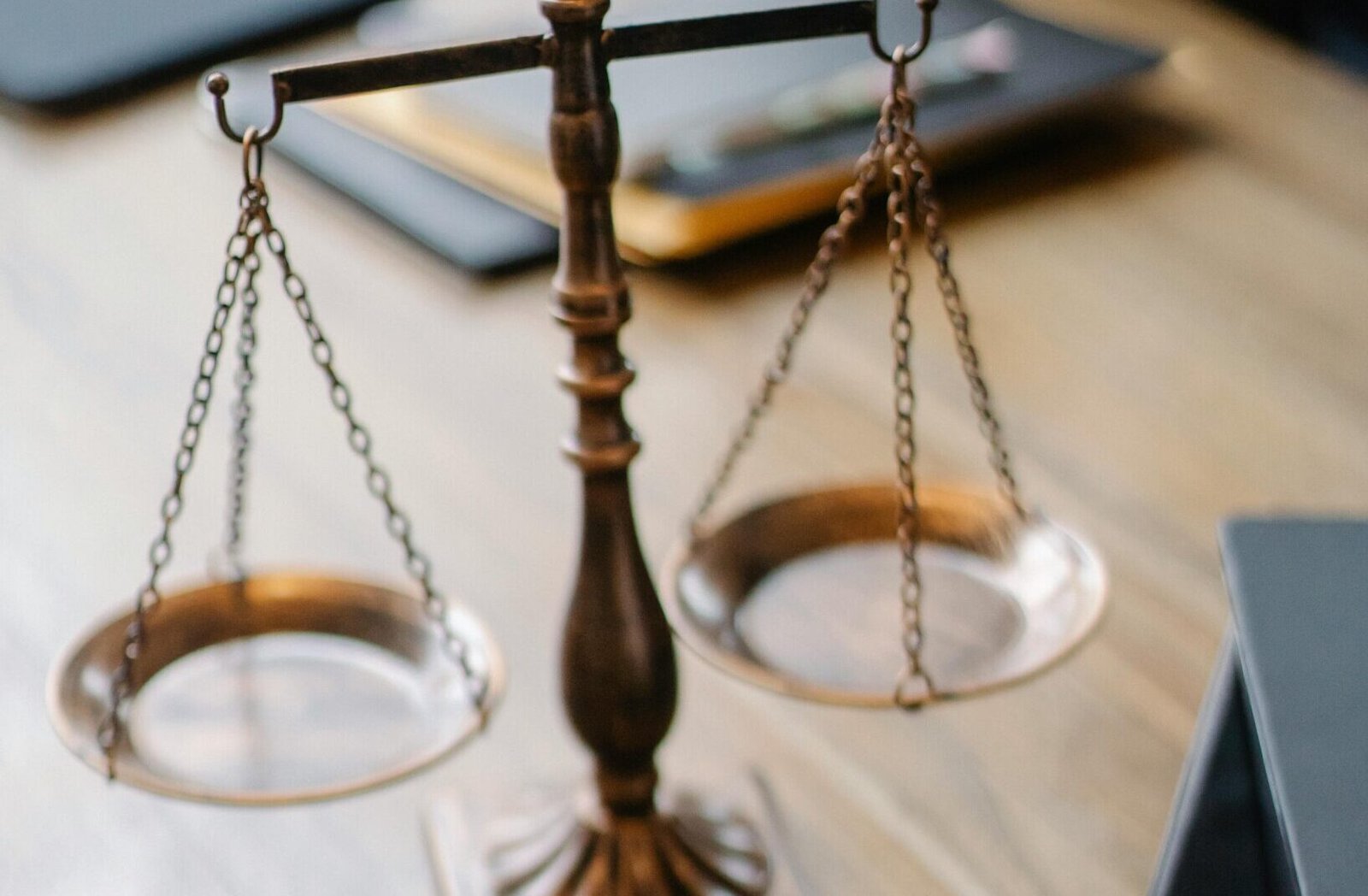 A striking image featuring a brass justice scale and gavel on a wooden desk, symbolizing law and justice.